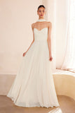 Woman wearing a strapless white wedding dress in a softly lit room.Strapless Chiffon A-Line Wedding Gown with Matching Neck Scarf by Ladivine T703W