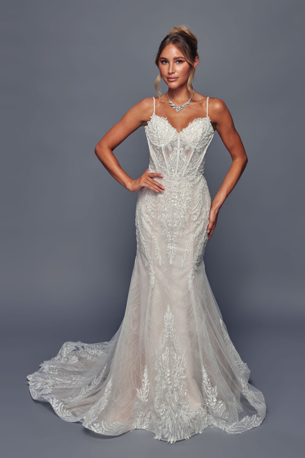 Woman wearing a white lace wedding dress against a gray background.DeKlaire Bridal 499 wedding dress – www.snkdress.com